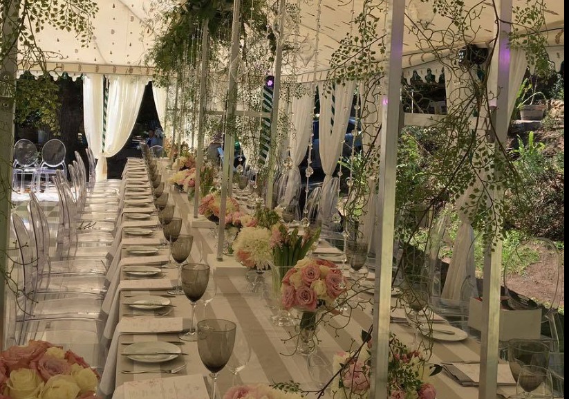 Marquee reception with long tables, floral styling and hanging greenery